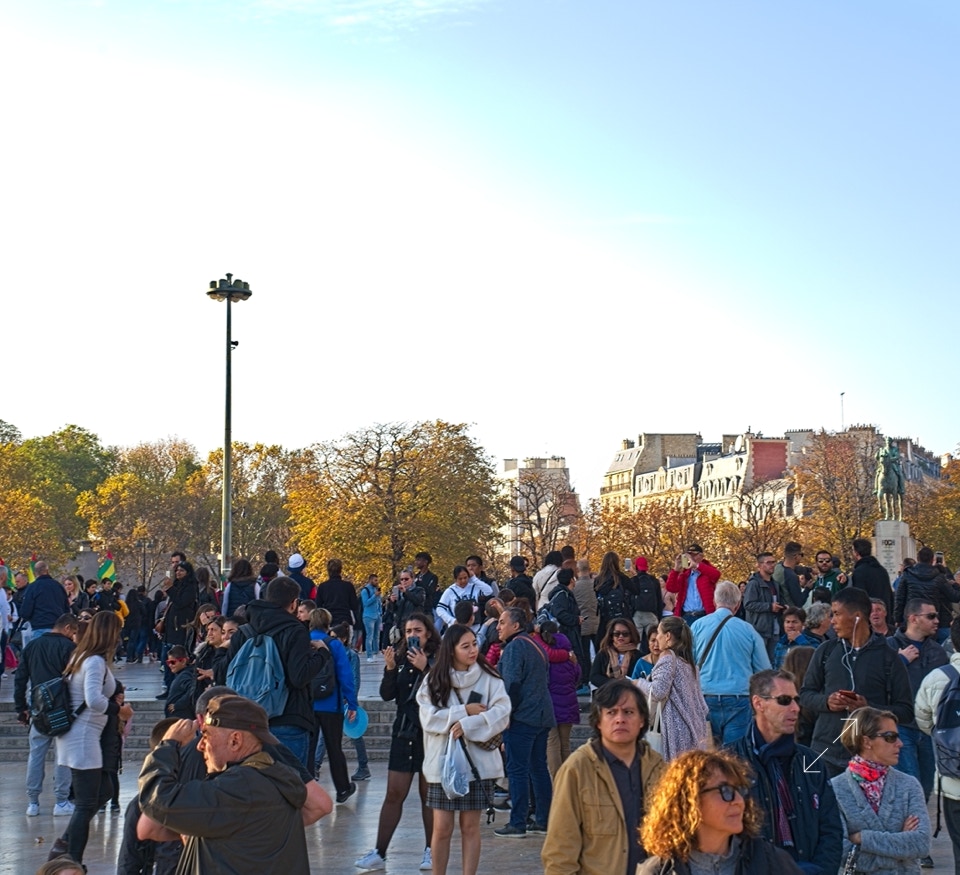 Crowds come to see the Eiffel at sunset.